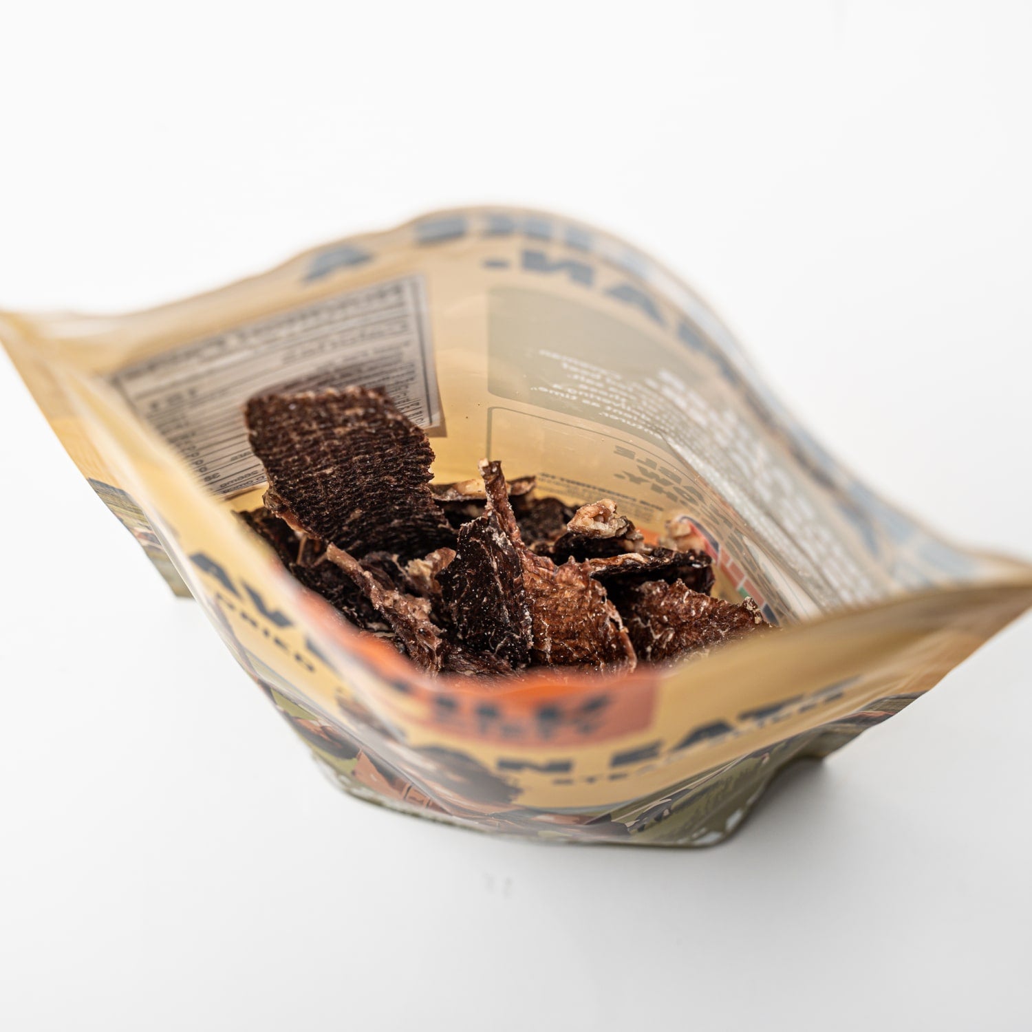 Open bag of chocolate cookies on a white background